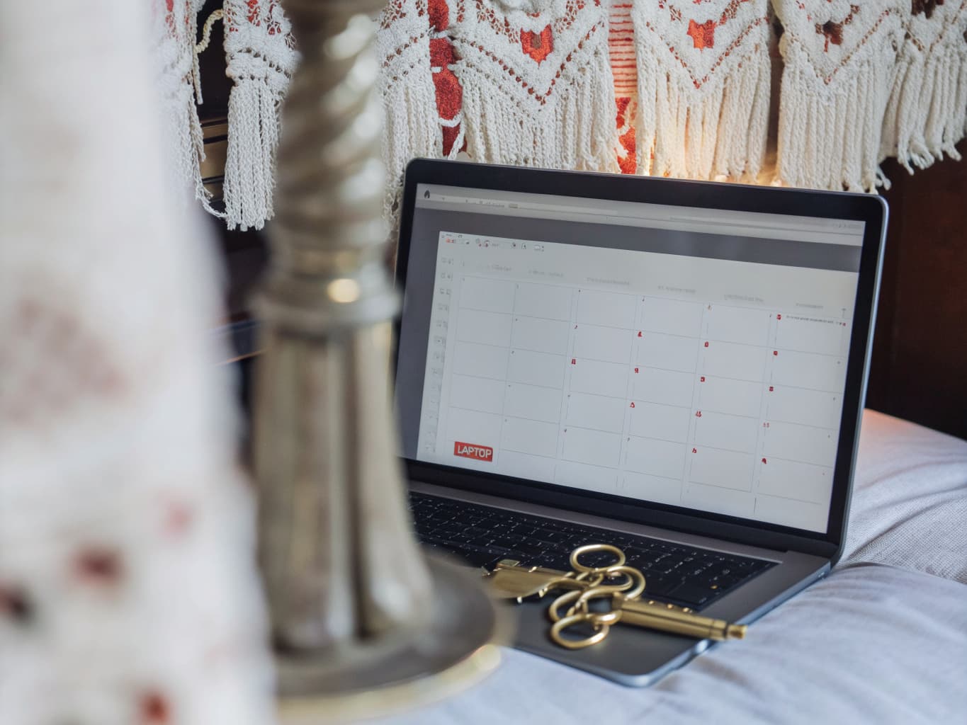 Bed and breakfast OTA listing optimization: booking calendar on a laptop beside vintage room keys