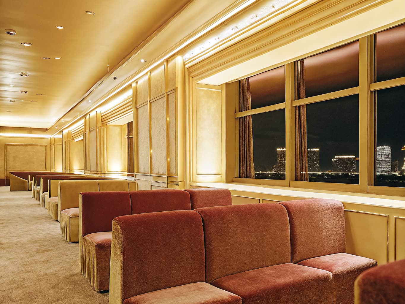 Upscale casino VIP lounge with velvet seating and city skyline view at night