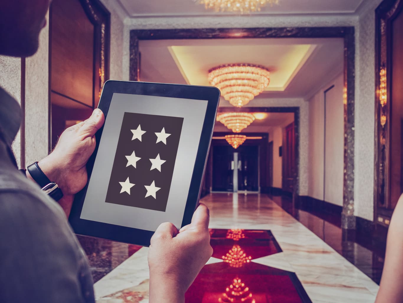 Casino reputation and review management: tablet showing five star ratings in a glowing resort lobby