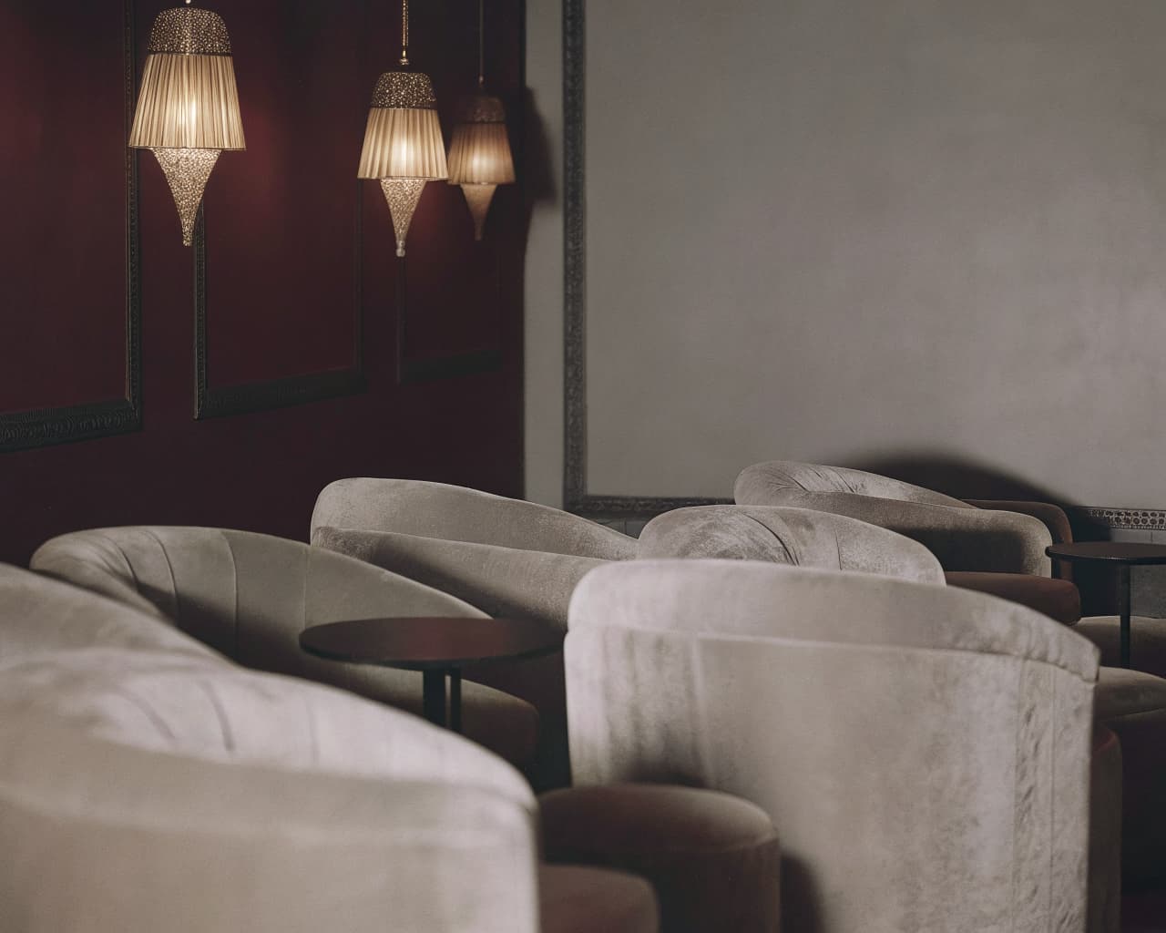 Elegant lounge seating area with velvet armchairs and warm amber pendant lighting