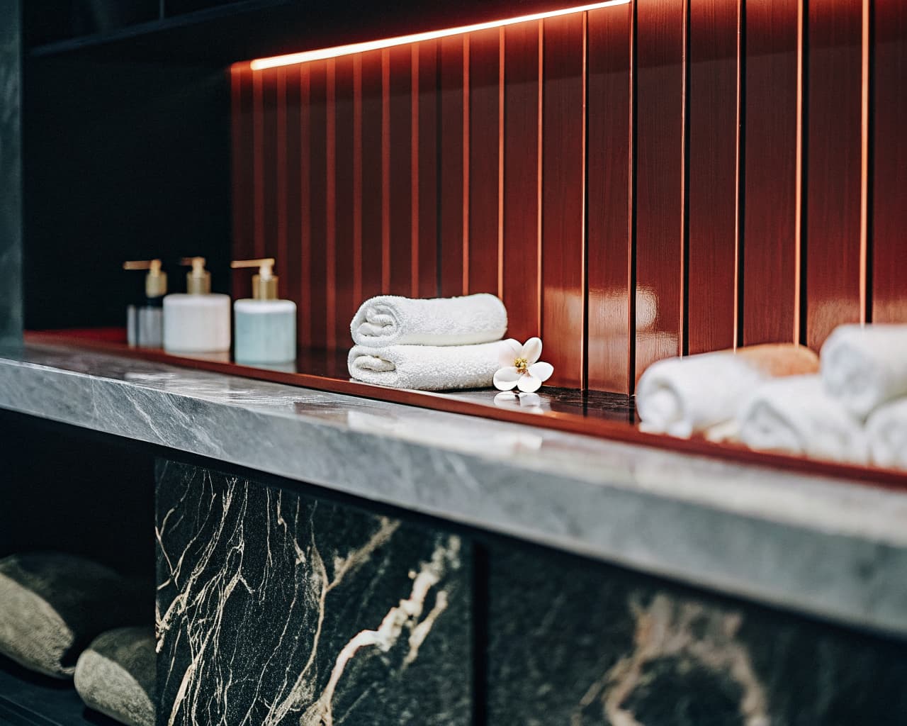 Elegant spa retail counter with rolled towels and skincare products