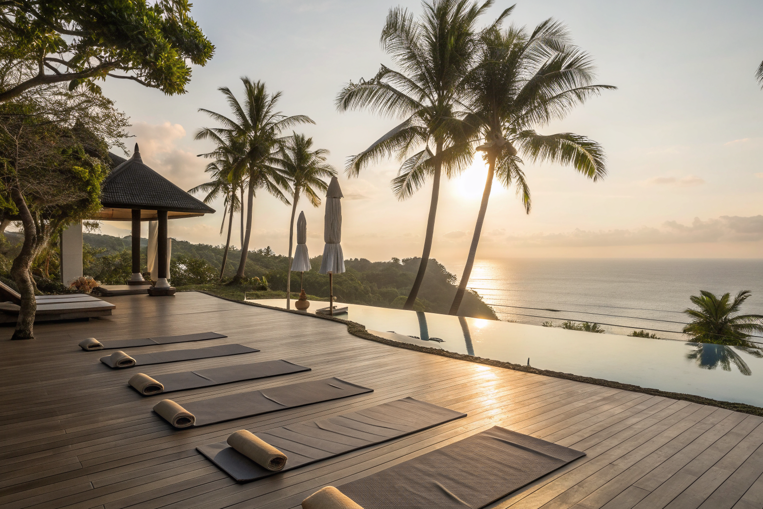 Outdoor yoga deck overlooking an infinity pool and ocean at a tropical resort retreat